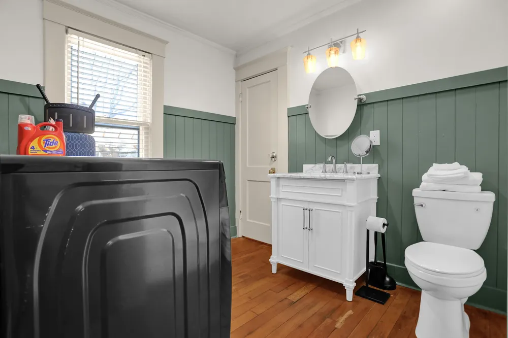 Washer and dryer in a room with green panelling.